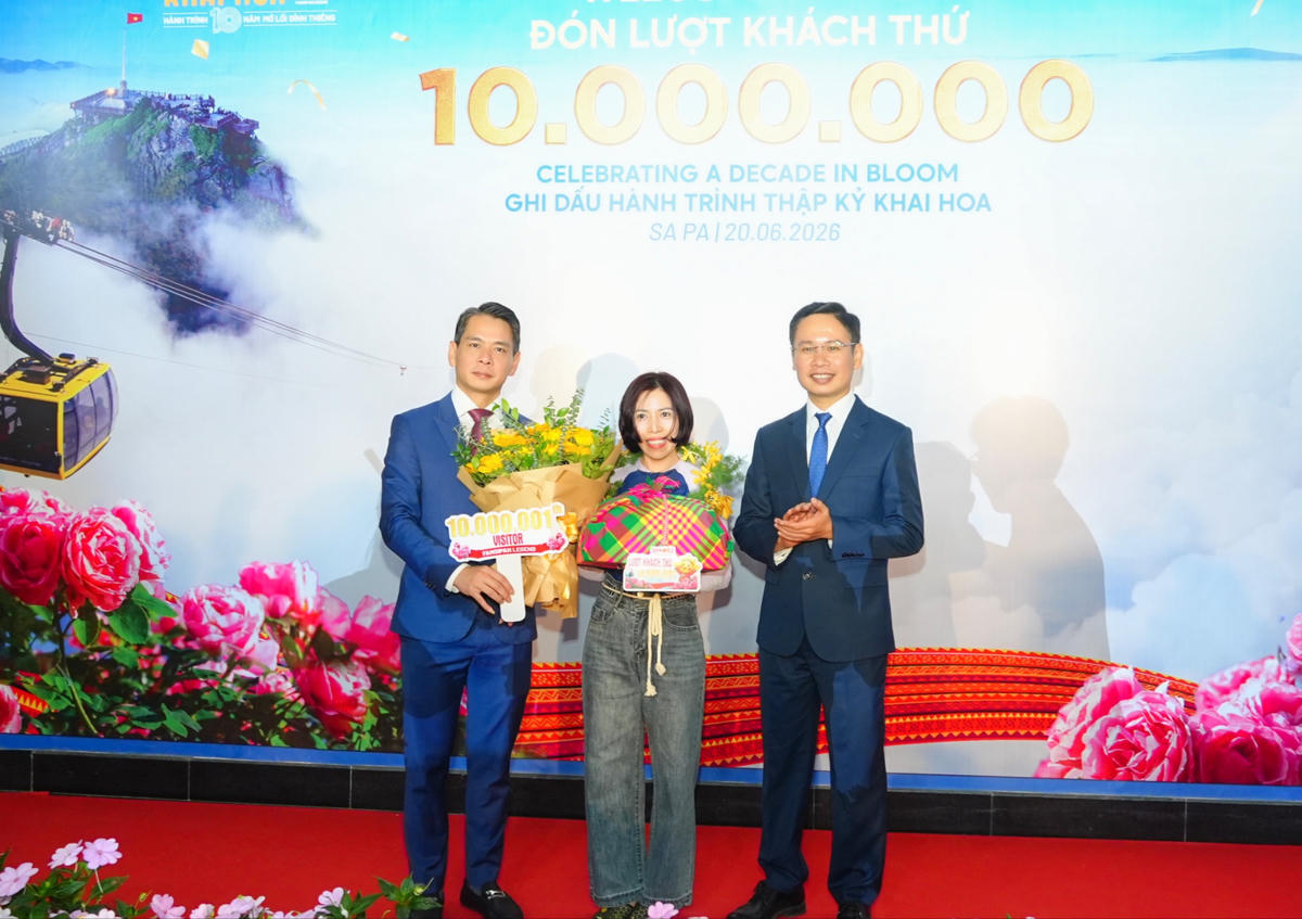 Ông Đặng Việt Dũng, Ủy viên Ban Thường vụ Đảng ủy phường, Phó Chủ tịch Thường trực UBND phường Sa Pa (bên trái) trao quà cho vị khách 10.000.001.