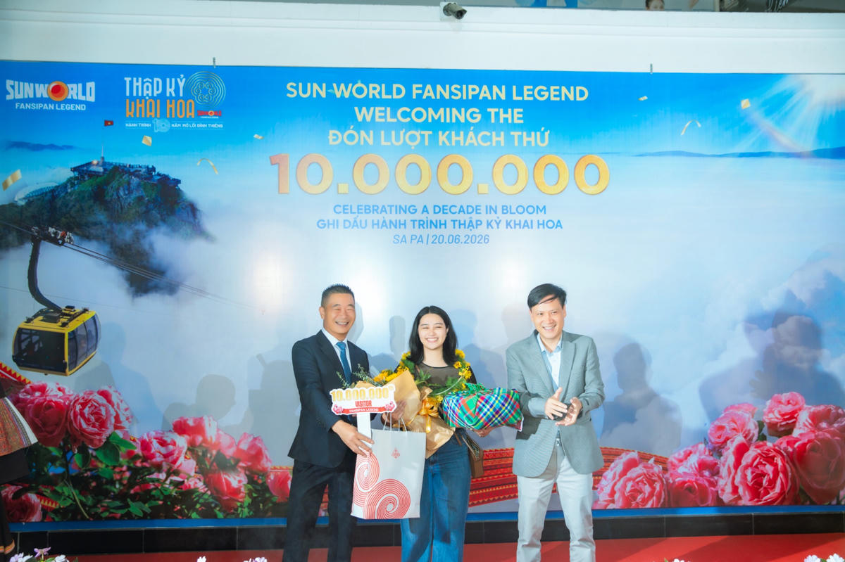 Ông Phạm Cao Vỹ - Chủ tịch Hiệp hội Du lịch tỉnh Lào Cai (bên trái) trao quà tặng cho vị khách thứ 10 triệu.
