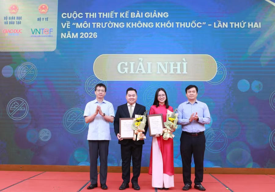 Ông Nguyễn Ngọc Ân, Chủ tịch Công đoàn Giáo dục Việt Nam và ông Doãn Hồng Hà, Phó Trưởng ban Tuyên giáo và Dân vận Đảng ủy (Bộ GDĐT) trao giấy chứng nhận và tặng hoa cho các tác giả có tác phẩm xuất sắc đạt giải Nhì.