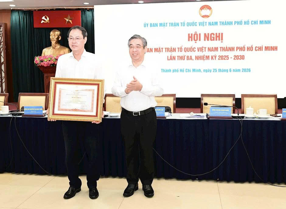 Phó Bí thư Thành ủy, Chủ tịch Ủy ban MTTQ Việt Nam TP Hồ Chí Minh Nguyễn Phước Lộc trao Bằng khen của Thủ tướng Chính phủ cho ông Nguyễn Thành Trung. Ảnh: VM.