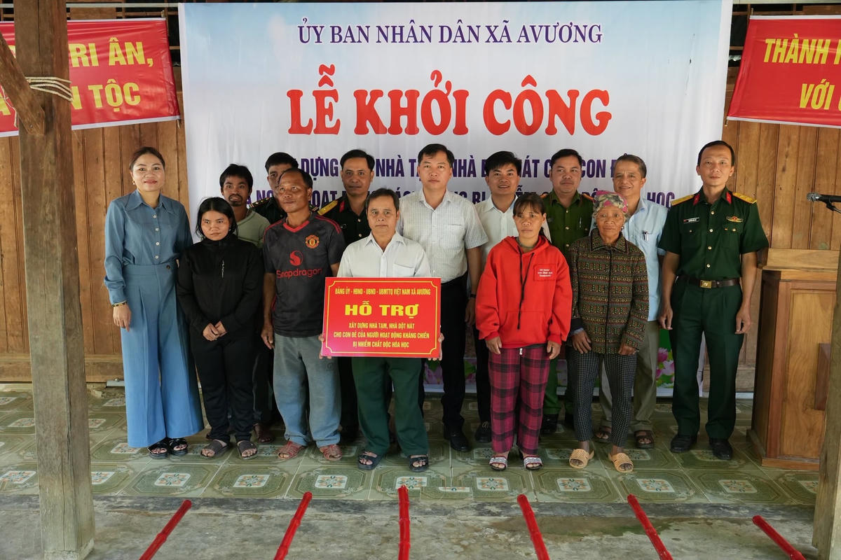 Lãnh đạo UBND xã A Vương trao hỗ trợ xóa nhà tạm, nhà dột nát cho con đẻ của người hoạt động cách mạng bị nhiễm chất độc hóa học. Ảnh: AV.
