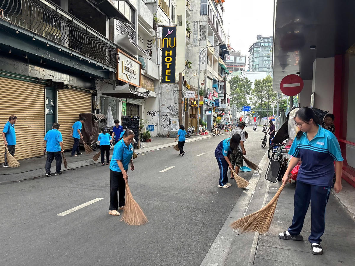 Ngay sau lễ phát động, nhân dân phường Bến Thành tham gia quét dọn vệ sinh đường phố tại tuyến hẻm trên đường Bùi Viện. Ảnh: TL.