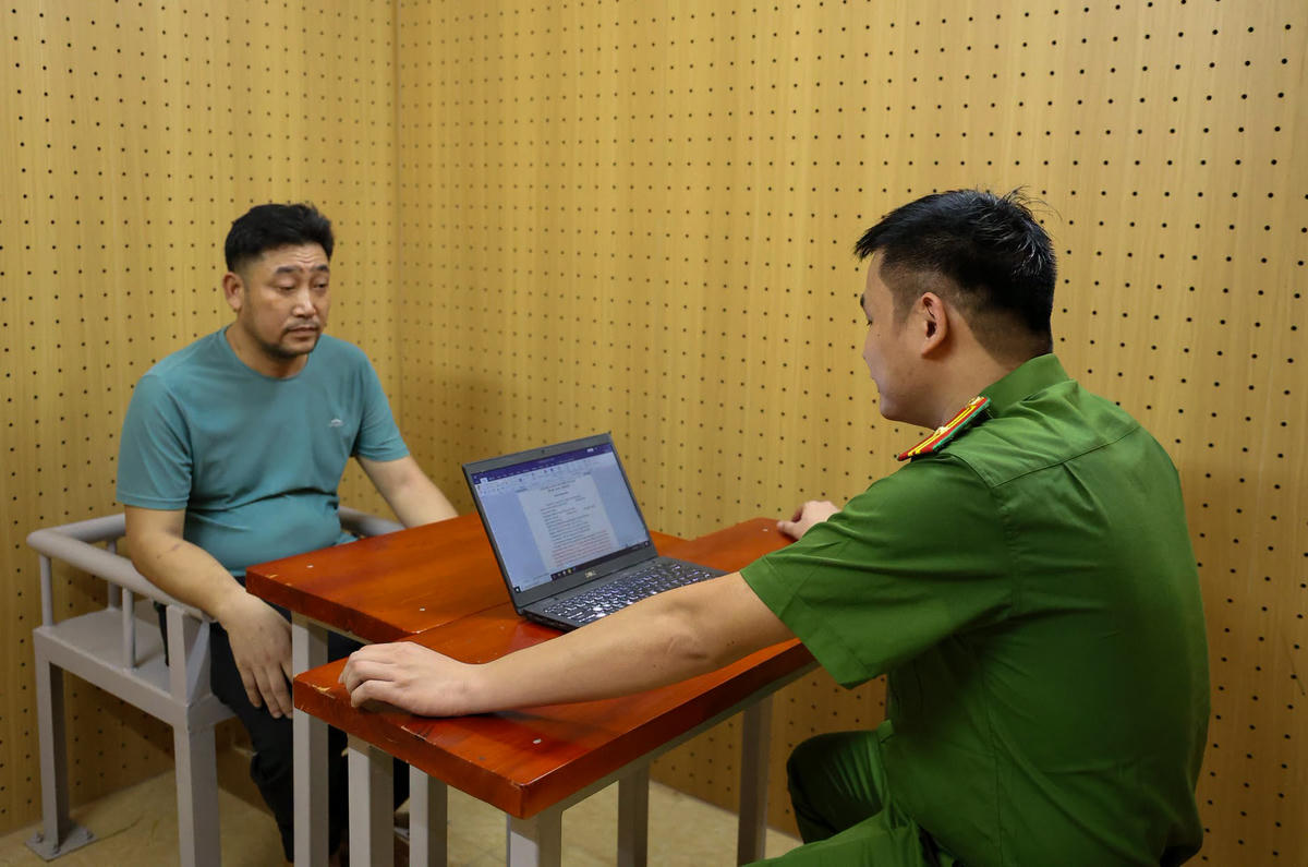 Cơ quan công an lấy lời khai của Nguyễn Đình Giáp - người có vai trò phiên dịch trong đường dây. Ảnh: CAHT
