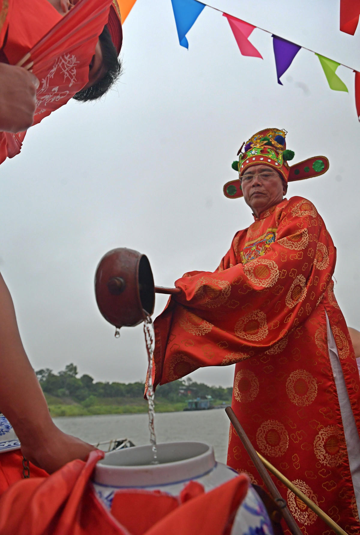 Chủ tế dùng gáo múc nước dưới sông Hồng vào chóe.