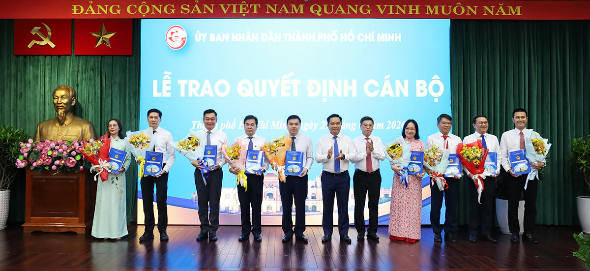 Lãnh đạo UBND thành phố trao quyết định cán bộ và tặng hoa. Ảnh: UB