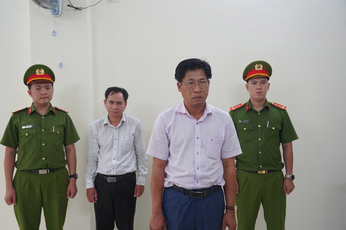 Cơ quan Cảnh sát điều tra Công an tỉnh Khánh Hòa tống đạt các quyết định liên quan đối với 2 bị can Hán Tấn Vĩnh An (áo trắng, đứng trước), Nguyễn Hữu Tân (áo trắng, đứng sau)