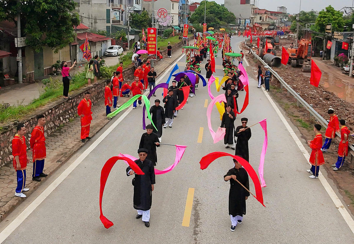 Đoàn rước kéo dài trên bờ đê với sự tham gia của đông đảo cộng đồng dân cư, tạo nên không khí của lễ hội đặc sắc và độc đáo lâu đời. 
