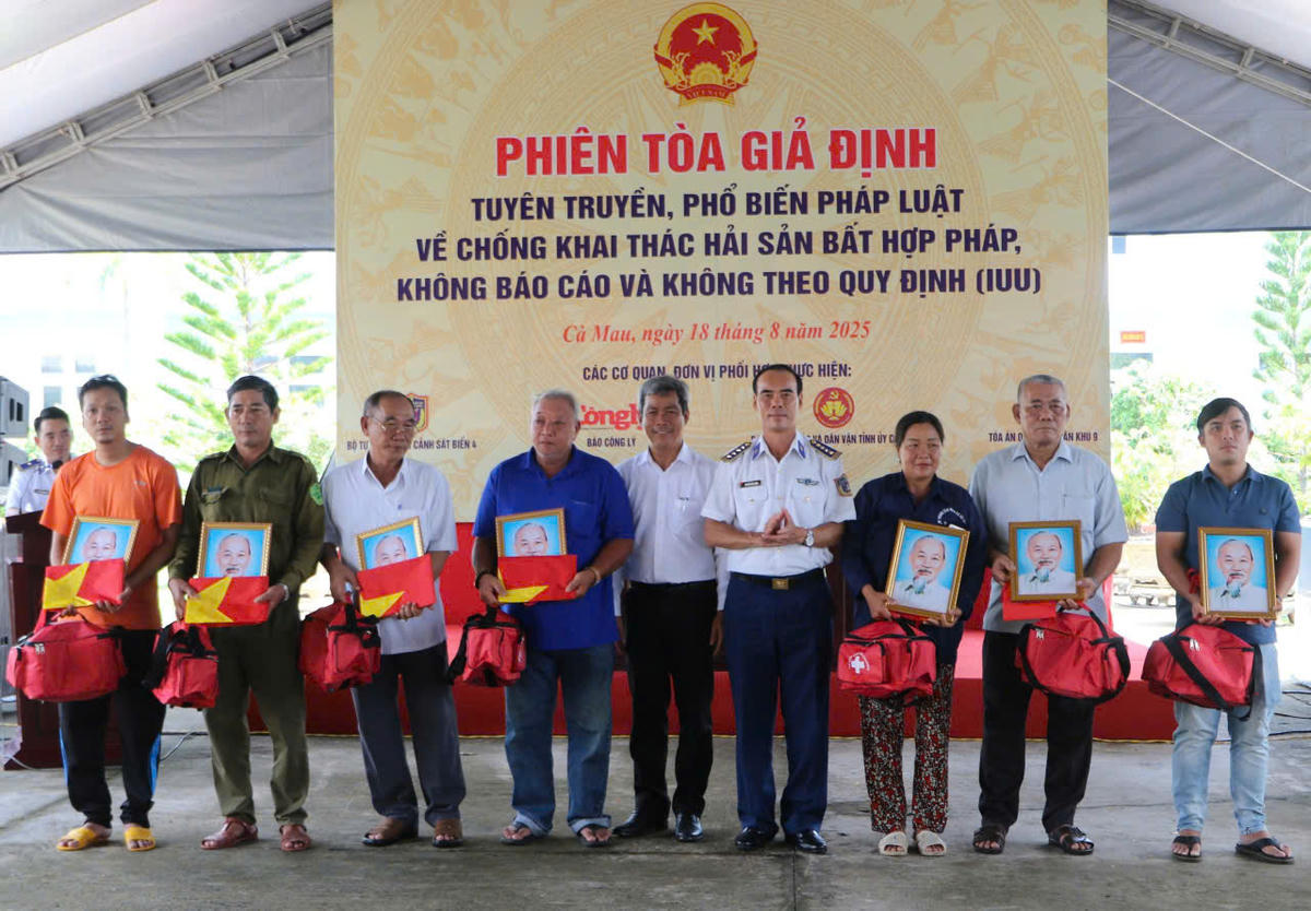 Tặng cờ và ảnh bác cho bà con ngư dân là hoạt động thiết thực mang theo thông điệp về kỷ cương pháp luật, về ý thức trách nhiệm khi hành nghề trên biển. Ảnh: Nguyên Du