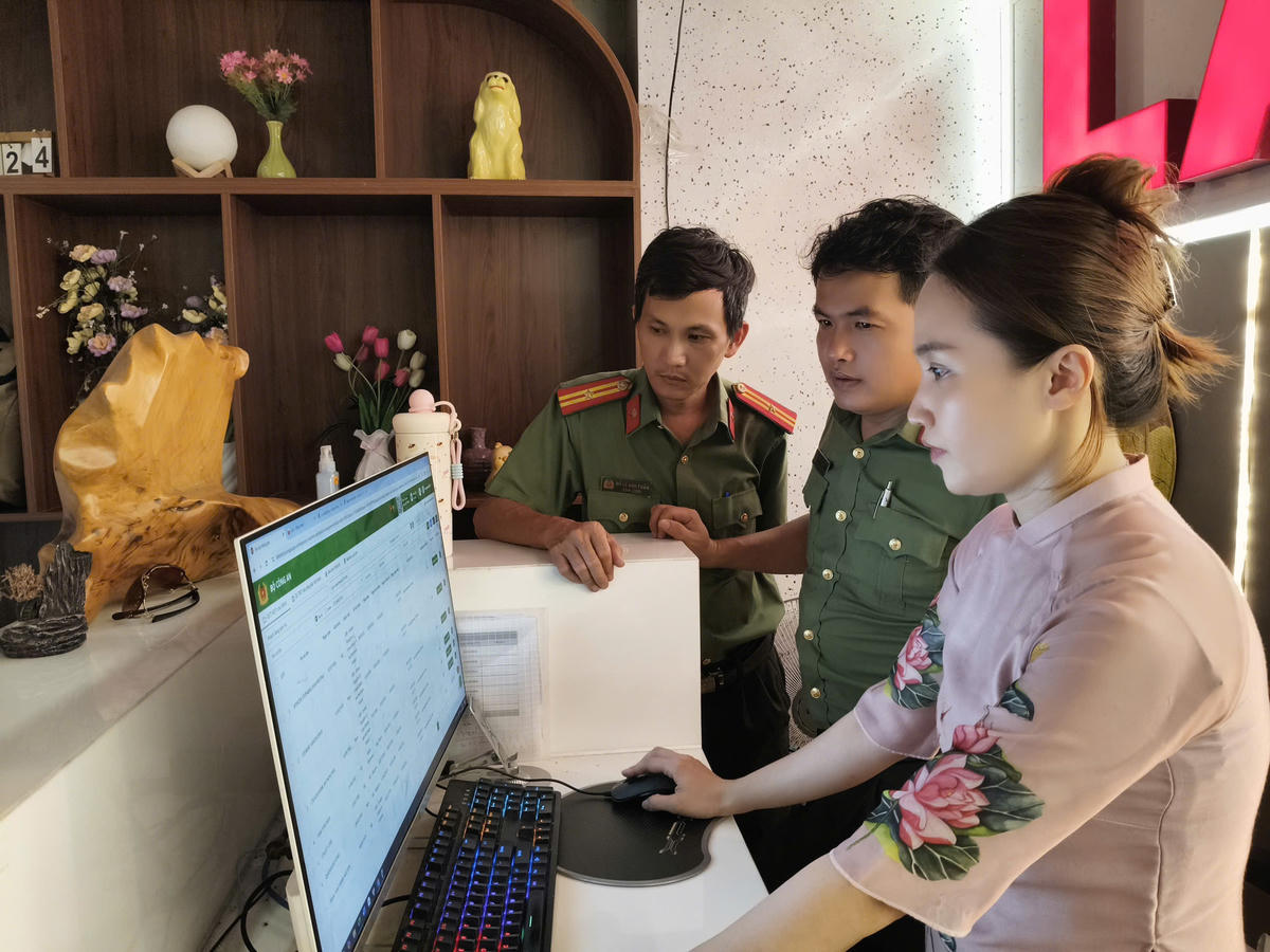 Công an phường Cẩm Lệ kiểm tra hồ sơ, thông tin lưu trú của người nước ngoài tại cơ sở lưu trú. Ảnh: Nguyễn Tú