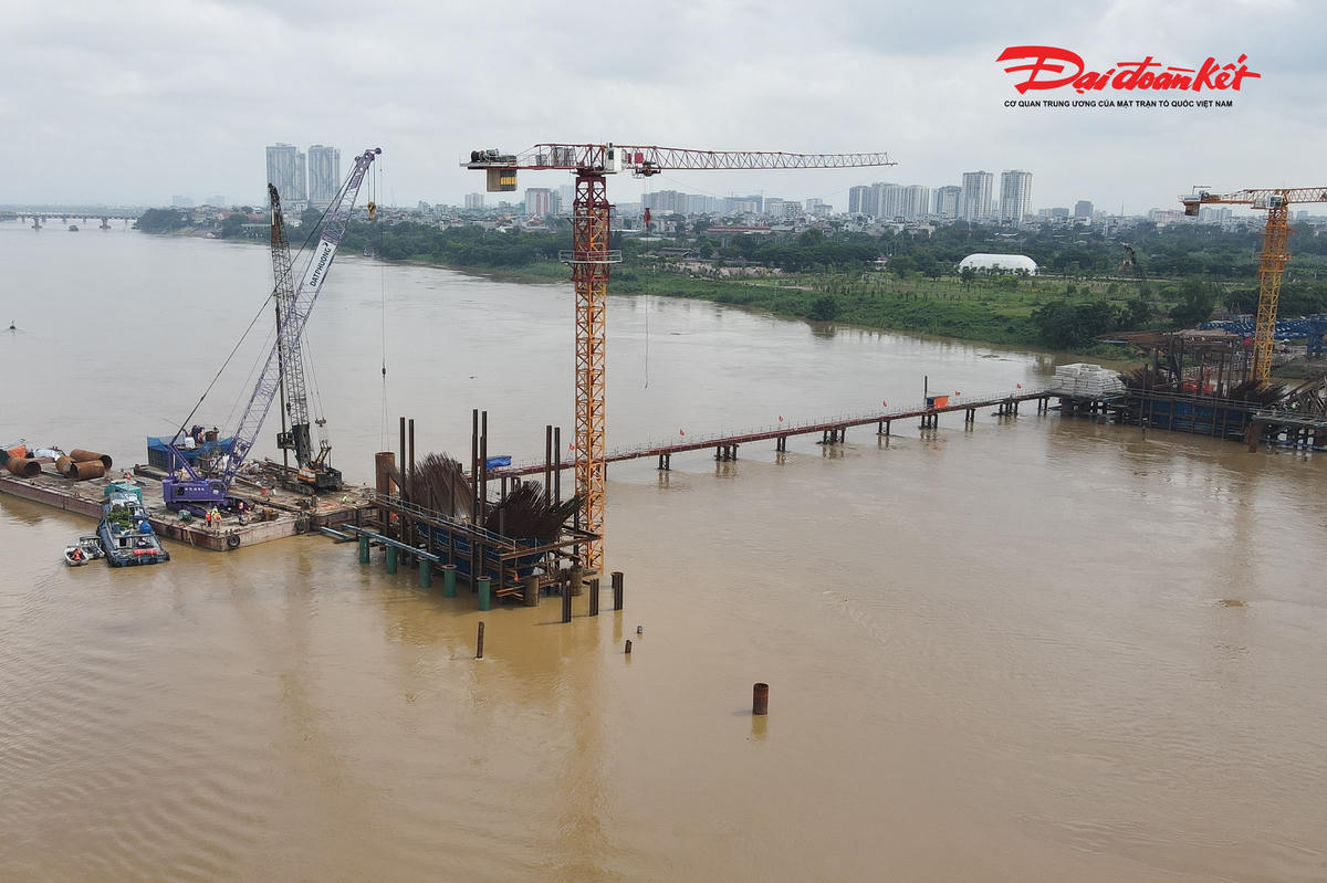 Theo ghi nhận của PV Báo Đại đoàn kết tại công trường cầu Trần Hưng Đạo, nhiều thân trụ chính giữa sông đã vươn lên rõ nét, từng bước định hình diện mạo của cây cầu trong tương lai. Hàng trăm kỹ sư, công nhân cùng hệ thống cẩu lớn, sà lan và thiết bị chuyên dụng được huy động, làm việc liên tục để đẩy nhanh tiến độ các hạng mục.