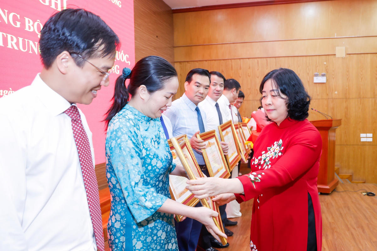 Chủ tịch Bùi Thị Minh Hoài trao tặng Bằng khen của Thủ tướng Chính phủ cho các tập thể, cá nhân đã có thành tích xuất sắc, tiêu biểu trong thực hiện Nghị quyết 18-NQ/TW. Ảnh: Quang Vinh.