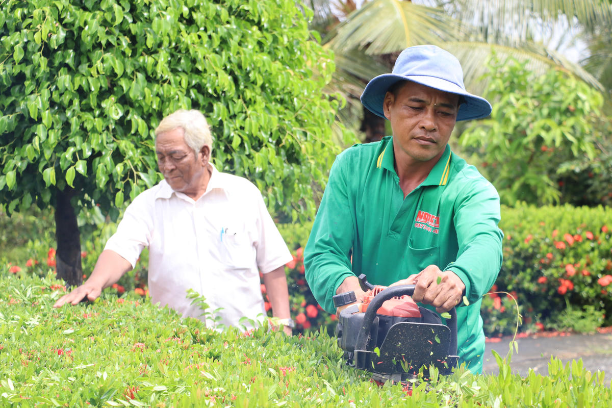 Ông Lâm Thu ( áo trắng) động viên người dân trồng hàng rào cây xanh ở địa phương. Ảnh: Nguyên Du
