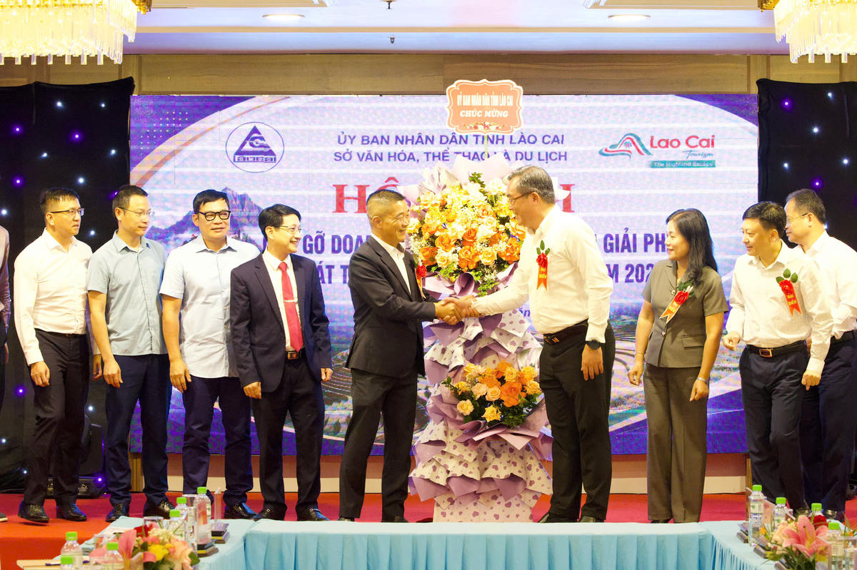 Ông Nông Việt Yên, Giám đốc Sở Văn hóa, Thể thao và Du lịch tỉnh Lào Cai tặng hoa chúc mừng hội nghị. Ảnh: Nguyễn Hải.