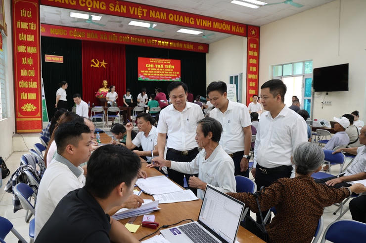 Ông Bùi Đình Thái - Phó bí thư Đảng ủy, Chủ tịch UBND xã trực tiếp kiểm tra công tác chi trả. Ảnh: TH.