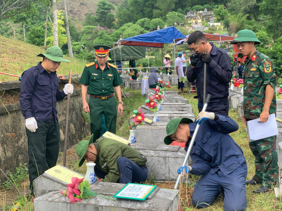 Cán bộ, chiến sĩ, lực lượng chức năng nỗ lực lấy mẫu ADN ở Nghĩa trang liệt sĩ Nầm. 	Ảnh: H.N