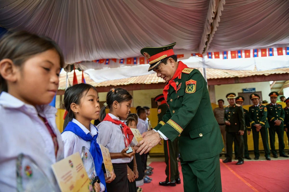 Đại tướng Phan Văn Giang - Ủy viên Bộ Chính trị, Phó Thủ tướng Chính phủ, Bộ trưởng Bộ Quốc phòng Việt Nam trao học bổng cho các em học sinh Trường Tiểu học Thông-năm-mun, bản Xốp-tờng. Ảnh: Nam Trần