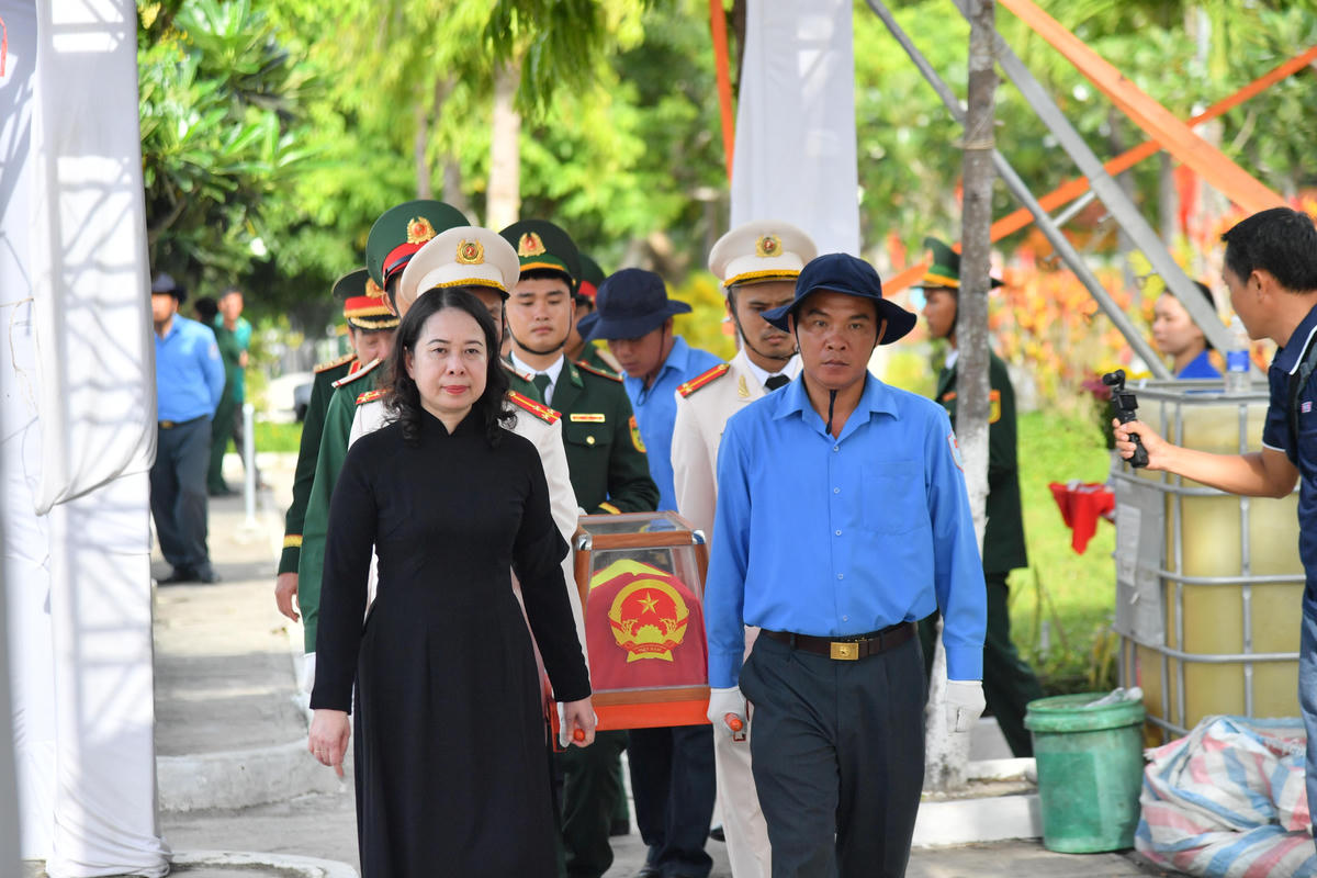 Phó Chủ tịch nước Võ Thị Ánh Xuân cùng các lực lượng trang trọng di chuyển hài cốt liệt sĩ đến khu vực an táng. Ảnh: Phương Vũ