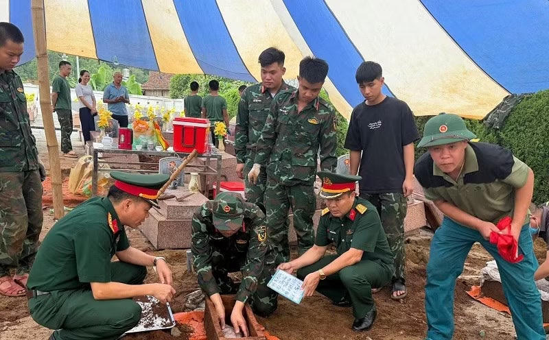 Lực lượng chức năng thực hiện quy trình lấy mẫu tại các phần mộ liệt sĩ.
