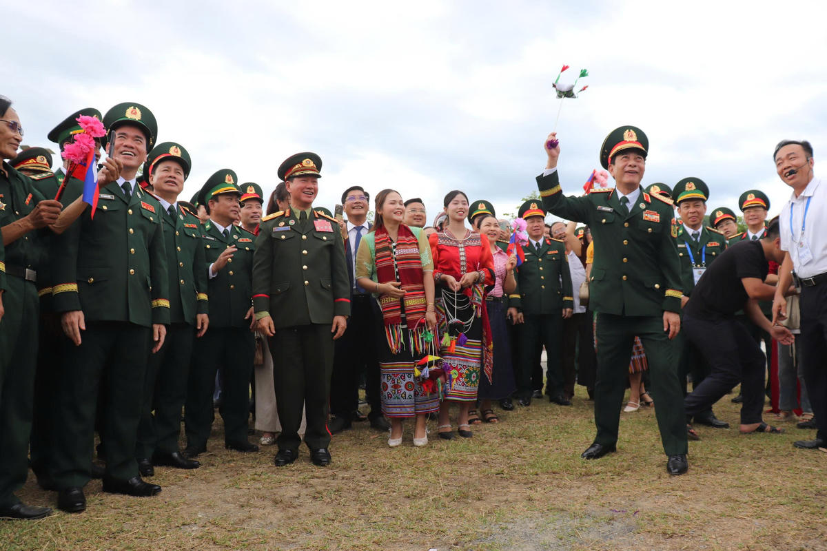 Hai Bộ trưởng Quốc phòng hai nước cùng các đại biểu tham gia trò chơi ném còn, nét đẹp văn hóa của đồng bào dân tộc Thái ở Nghệ An. Ảnh: Viết Lam