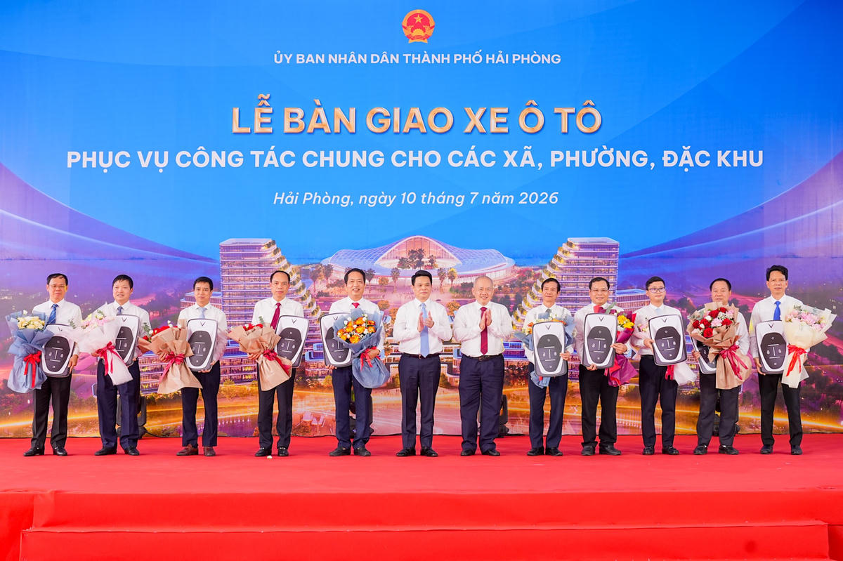 Lãnh đạo thành phố trao biểu trưng bàn giao xe ô tô điện cho đại diện các địa phương. Ảnh: ĐT.