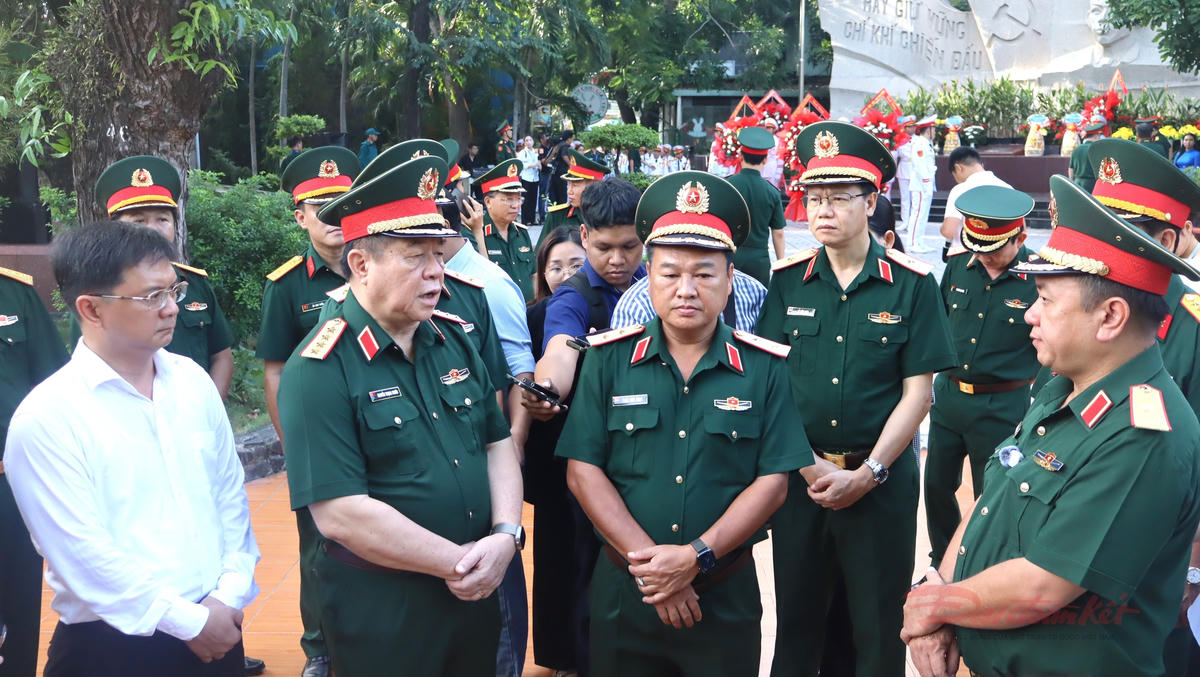 Đại tướng Nguyễn Trọng Nghĩa và đoàn công tác nghe báo cáo công tác tìm kiếm, quy tập hài cốt liệt sĩ tại Công viên Lê Thị Riêng. Ảnh: T.Luân.