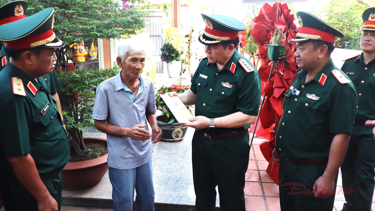 Đại tướng Nguyễn Trọng Nghĩa thay mặt đoàn công tác tặng quà cho nhân chứng Nguyễn Văn Định có mặt tại Công viên Lê Thị Riêng sáng 11/7. Ảnh: T.Luân.