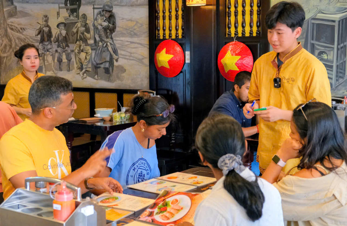 Khách nước ngoài thưởng thức món ăn Việt Nam. Ảnh: H.G