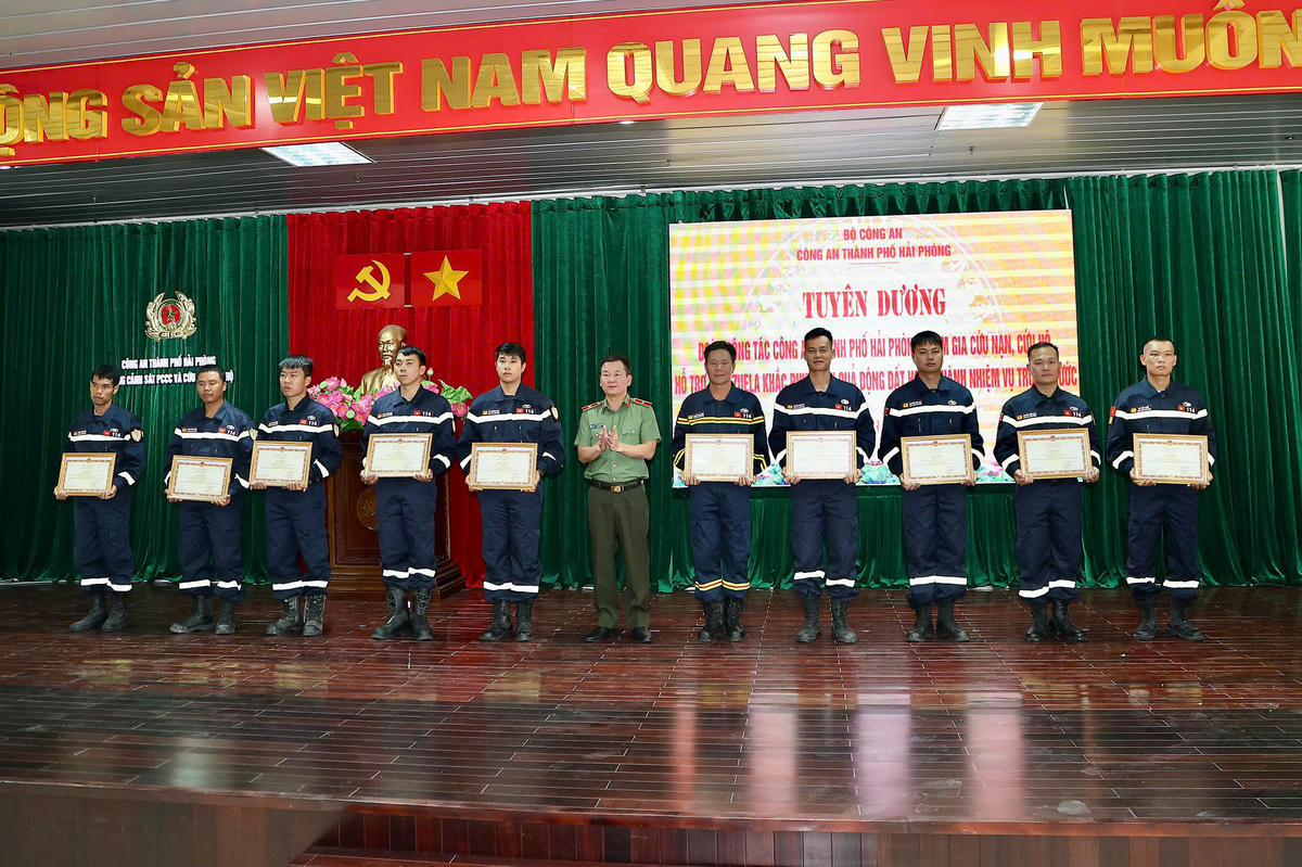 Thừa ủy quyền của Bộ trưởng Bộ Công an, Thiếu tướng Bùi Quang Bình, Giám đốc Công an thành phố trao tặng Bằng khen của Bộ trưởng Bộ Công an cho 10 cán bộ, chiến sĩ vì đã có thành tích xuất sắc trong thực hiện nhiệm vụ quốc tế. Ảnh: Việt Cường. 