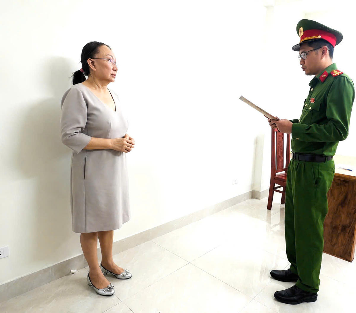 Bà Lê Thị Ngọc Mỹ (chủ tiệm vàng Kim Lý) nghe Công an đọc lệnh khởi tố. Ảnh: CATH