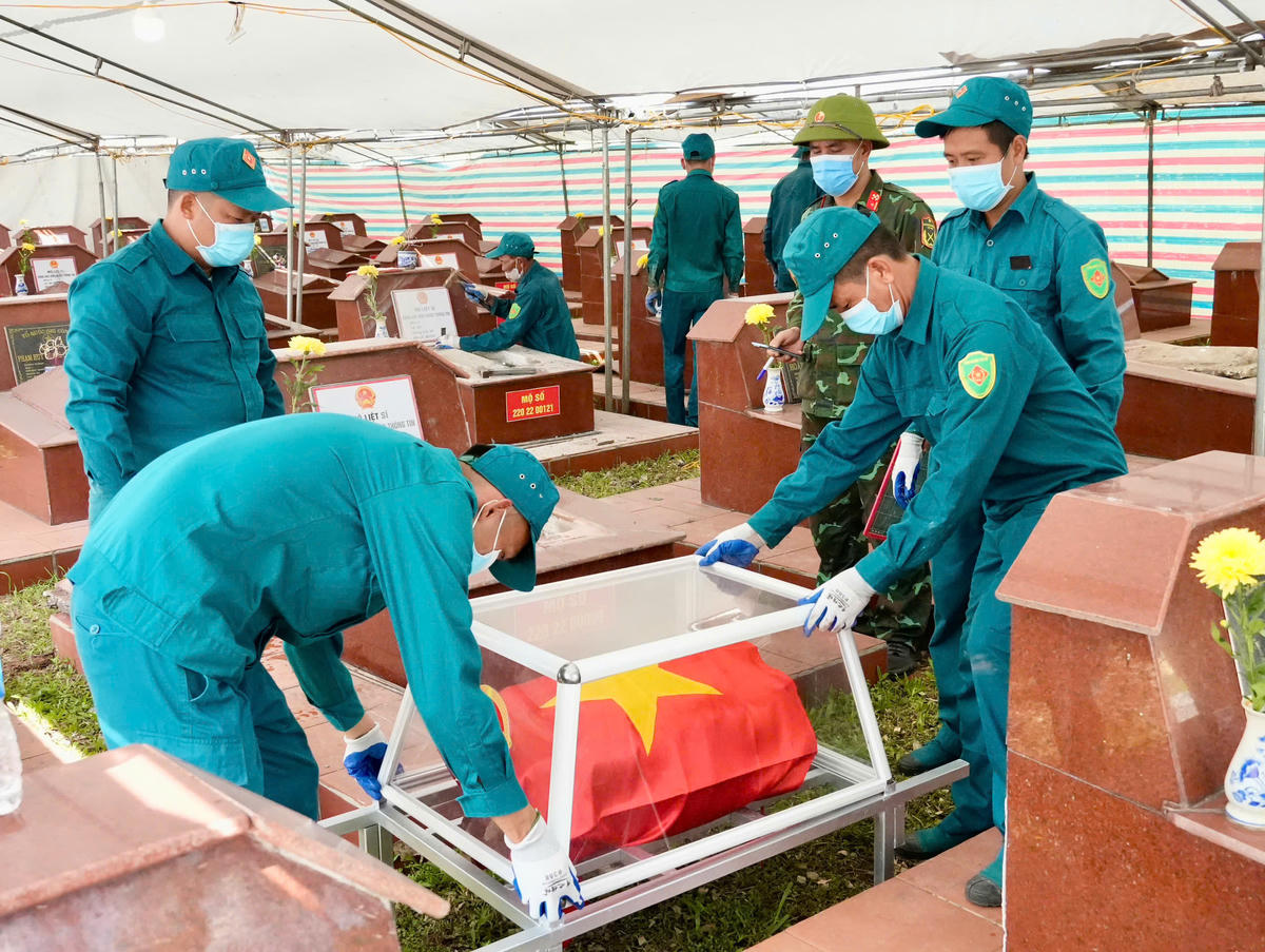 Các lực lượng phối hợp chặt chẽ trong quá trình thực hiện khai quật, lấy mẫu hài cốt liệt sĩ. Ảnh: QMG