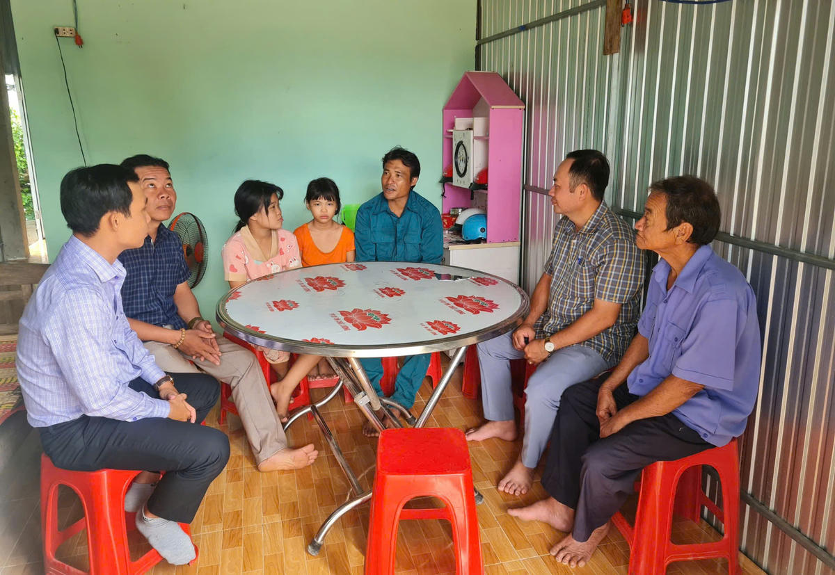 Anh Huỳnh Trí Trung ( người ngồi thứ ba từ trái sang) cùng với các con vui mừng chia sẻ niềm vui khi với chính quyền địa phương khi mong mỏi từ lâu của gia đình có được mái ấm che nắng, che mưa nay trở thành hiện thực. Ảnh: Nguyên Du