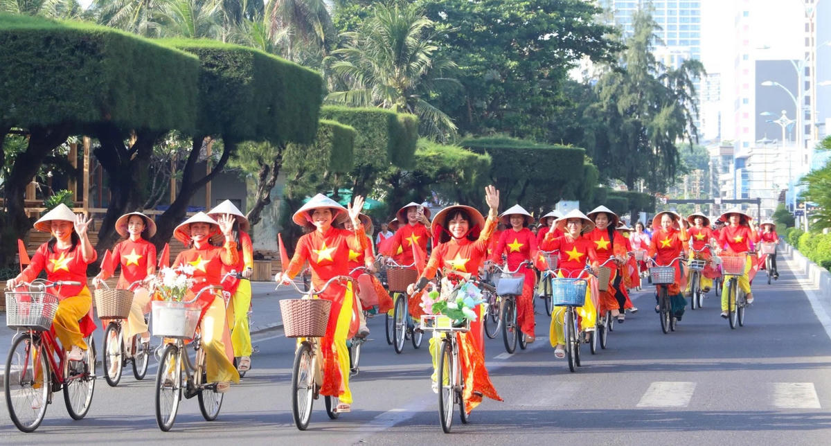 Diễu hành bằng xe đạp trên phố với  tà áo dài cờ đỏ sao vàng tại Festival Biển Khánh Hòa 2026. 