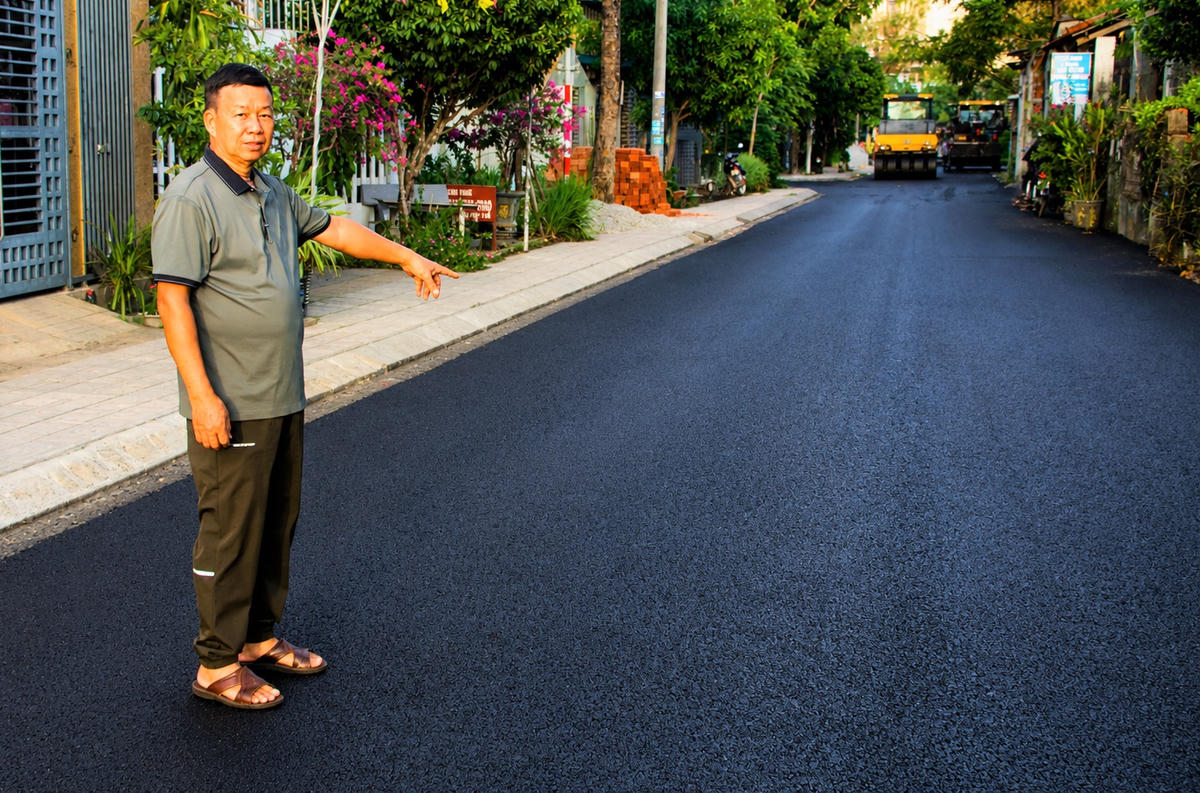 Ông Lê Văn Tuyển chỉ tuyến đường Nguyễn Thị Minh Khai đường thảm nhựa. Ảnh: Chí Đại.