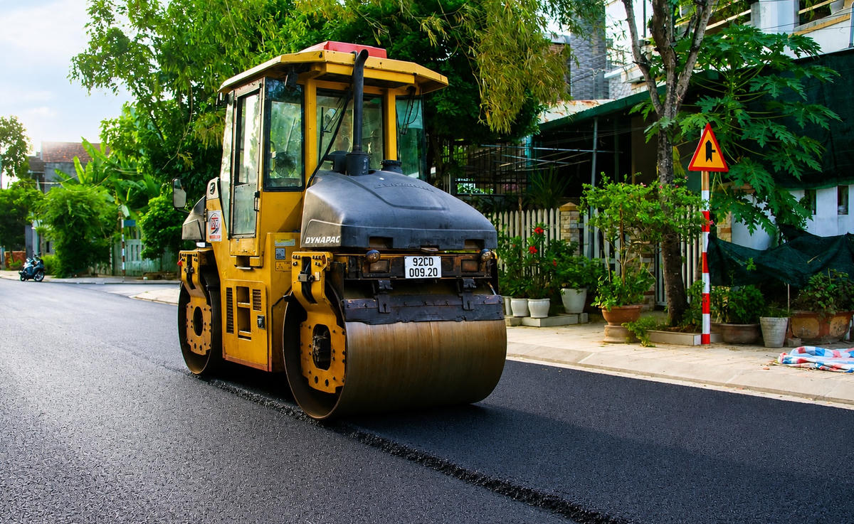 Xe lu đang thảm nhựa ở đường bao Nguyễn Hoàng. Ảnh: Chí Đại.