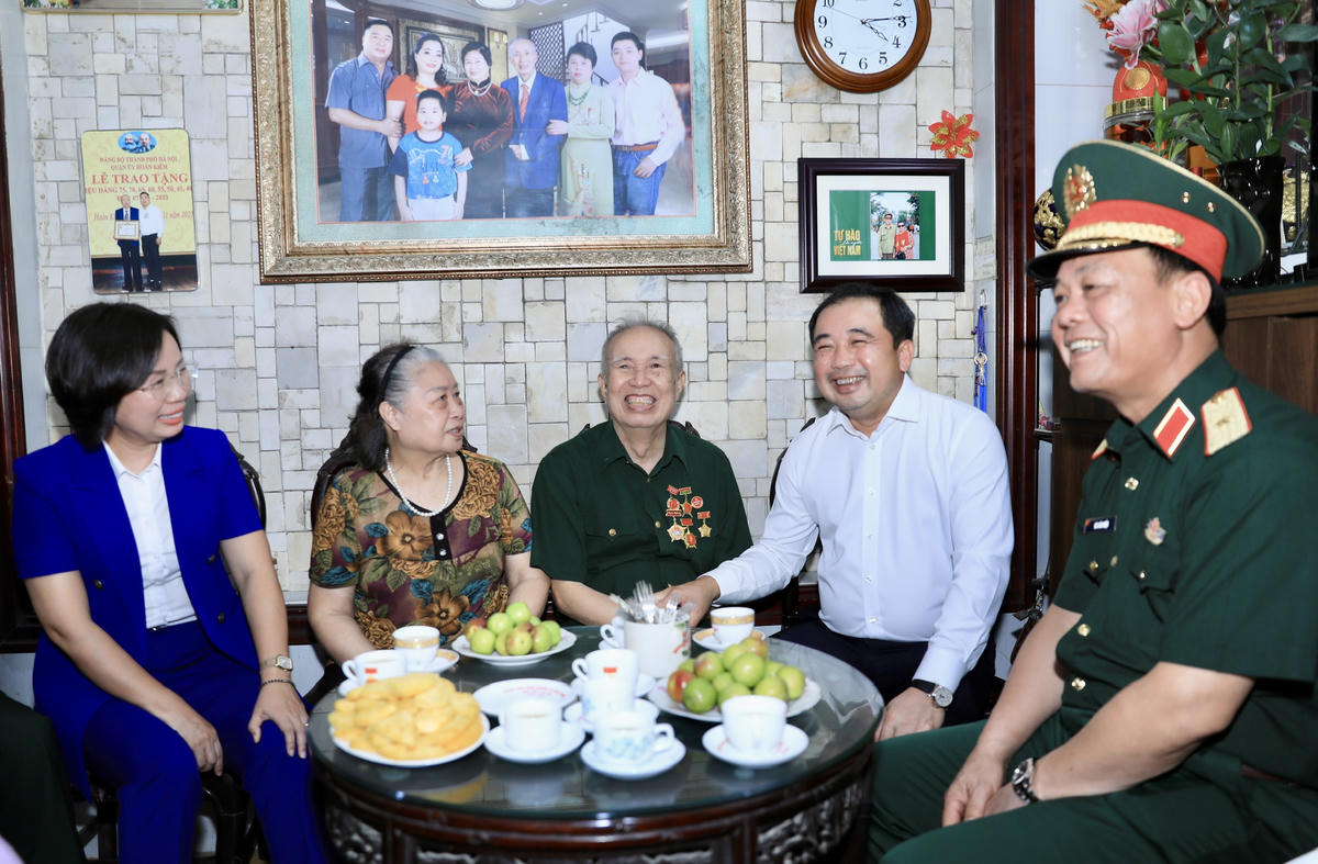 Bí thư Thành ủy Hà Nội Trần Đức Thắng thăm hỏi sức khỏe thương binh Vũ Đình Hồi. Ảnh: QT