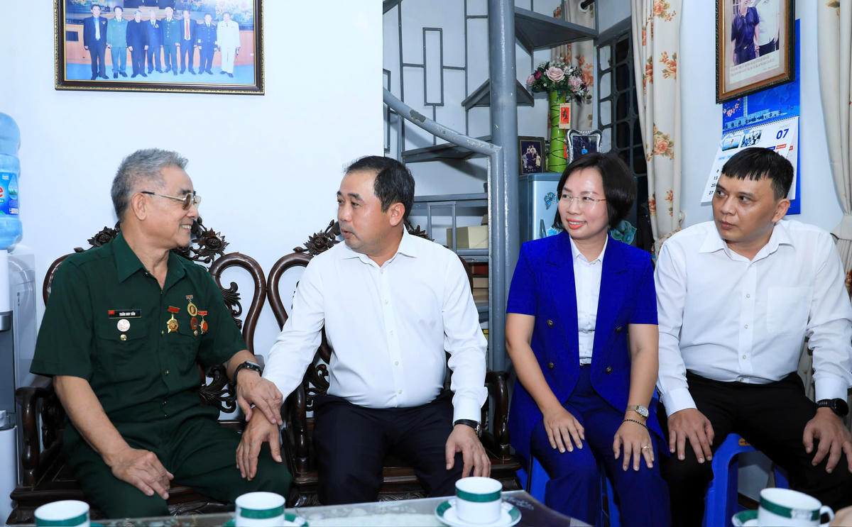 Bí thư Thành ủy Hà Nội Trần Đức Thắng thăm hỏi sức khỏe thương binh Trần Huy Tắn. Ảnh: QT