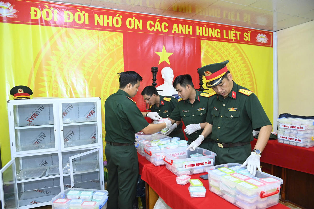 Đội tìm kiếm, quy tập hài cốt liệt sĩ (Bộ CHQS tỉnh Cà Mau ) thực hiện lấy mẫu sinh phẩm tại các mộ liệt sĩ để mang đi xét nghiệm ADN. Ảnh: VĐ