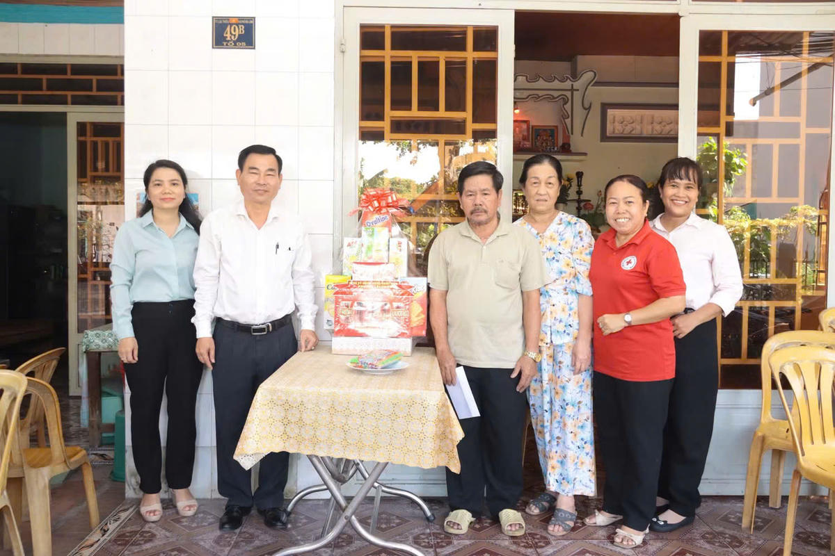 Ông Nguyễn Văn Minh thăm, tặng quà một gia đình có công với cách mạng trên địa bàn phường Lái Thiêu. Ảnh: NN.