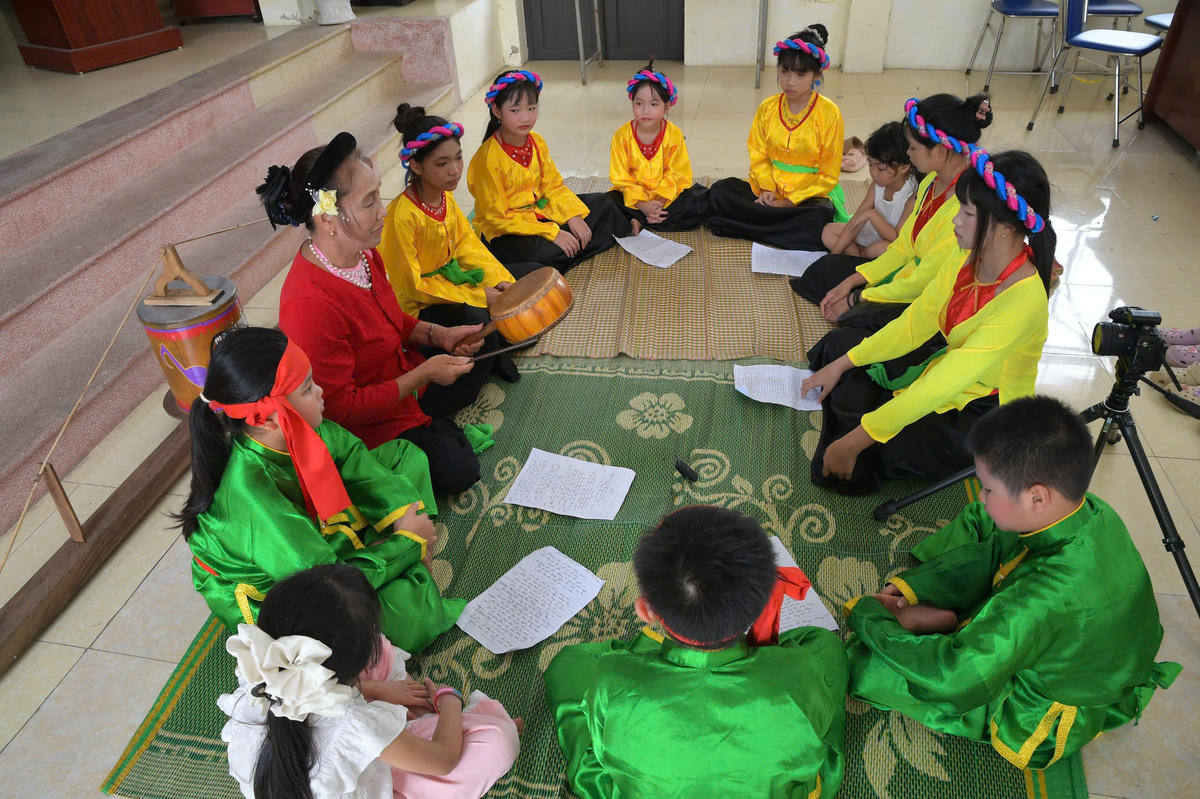 NNƯT Kiều Thị Mách truyền dạy những làn điệu hát trống quân cho các em nhỏ trong làng. 	Ảnh: P. Sỹ
