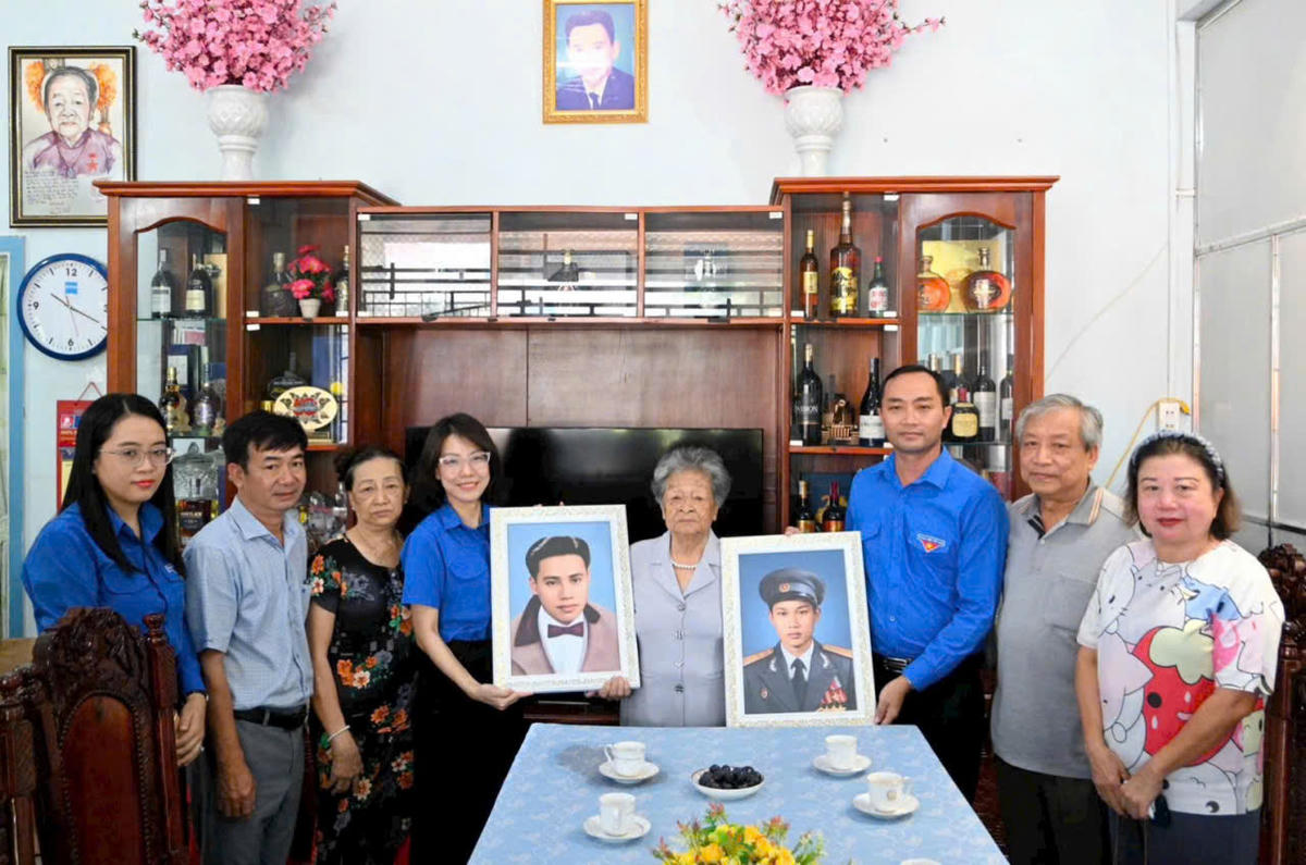 Đại diện Tỉnh đoàn trao ảnh chân dung phục dựng bằng công nghệ số của hai liệt sĩ là chồng và con trai Mẹ Nguyễn Kim Mai. Ảnh: Nguyên Du