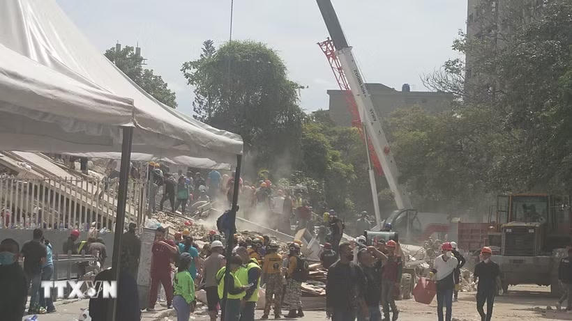 Các lực lượng cứu hộ Venezuela tìm kiếm những người mất tích và mắc kẹt dưới đống đổ nát. Ảnh: Phi Hùng/TTXVN).