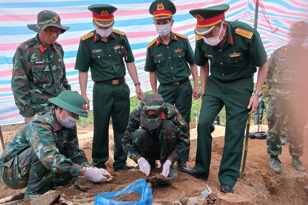 Cán bộ, chiến sĩ Đội tìm kiếm, quy tập hài cốt liệt sĩ thuộc Bộ Chỉ huy quân sự tỉnh Lào Cai đang gom lại những mảnh xương, di vật của các liệt sĩ một cách cẩn trọng, thành kính. Ảnh: Tuấn Trung.
