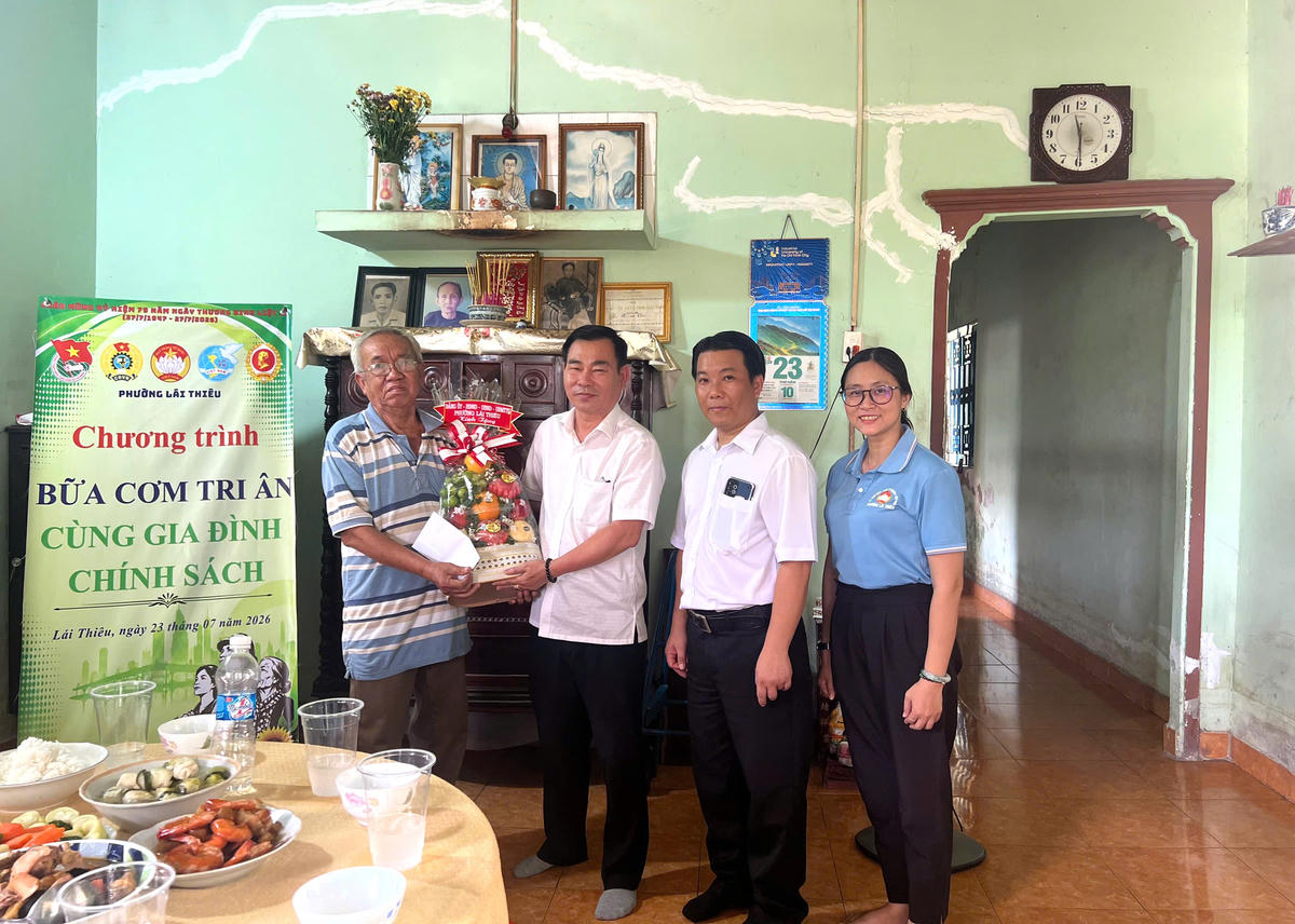 Ông Nguyễn Văn Minh - Ủy viên Ban Thường vụ Thành ủy, Bí thư Đảng ủy, Chủ tịch HĐND phường Lái Thiêu tặng quà cho một gia đình tại chương trình “Bữa cơm tri ân”. Ảnh: NN.