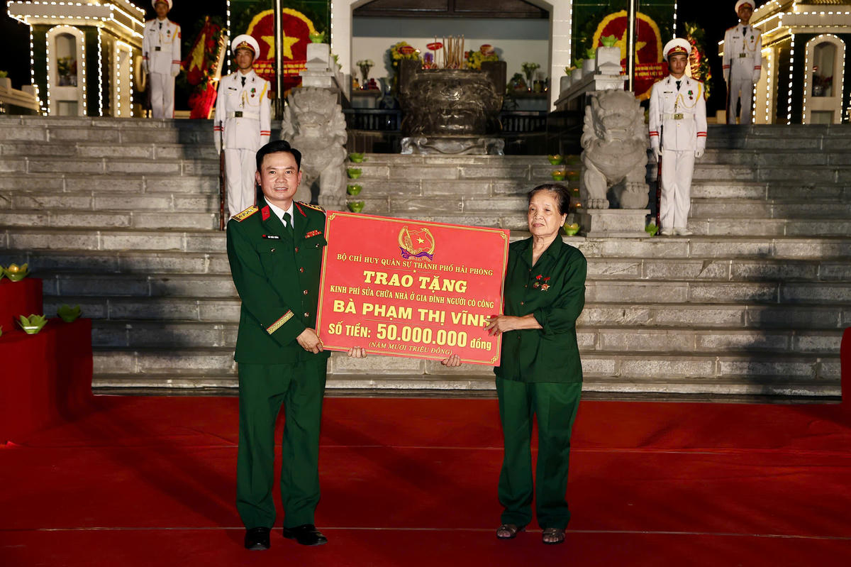 Lãnh đạo Bộ chỉ huy quân sự thành phố trao tặng kinh phí sửa chữa nhà ở cho gia đình bà Phạm Thị Vĩnh. Ảnh: PT.