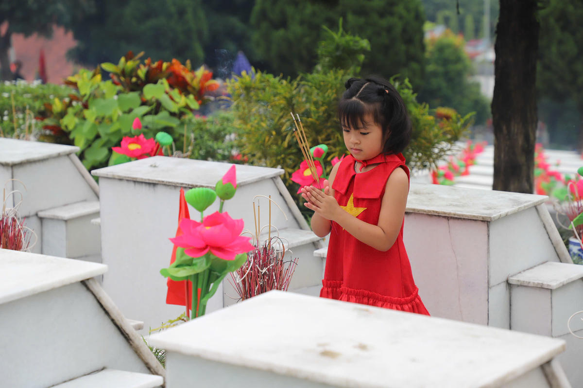 Các em nhỏ thành kính dâng hương tại phần mộ liệt sĩ, hình ảnh tiếp nối mạch nguồn tri ân giữa các thế hệ người Việt Nam.