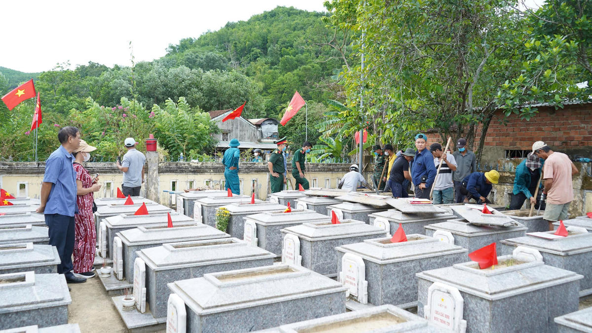 Ông Vũ Văn Minh ở phường Bắc An Phụ, TP Hải Phòng cùng người thân hướng ánh mắt về lực lượng chức năng đang lấy mẫu ADN hài cốt liệt sĩ tại Nghĩa trang Liệt sĩ xã Quế Lâm cũ. Ảnh: NT.