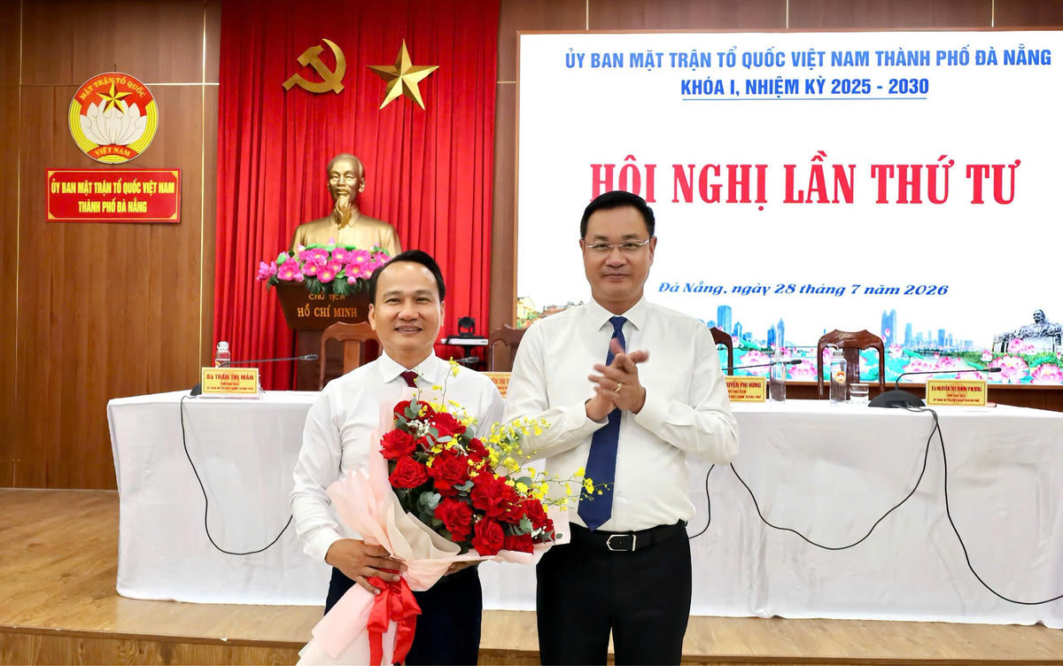 Bí thư Thành ủy Đà Nẵng Lê Ngọc Quang chúc mừng ông Nguyễn Đình Vĩnh, Chủ tịch Ủy ban Mặt trận Tổ quốc Việt Nam TP Đà Nẵng. Ảnh: Thái Cường.