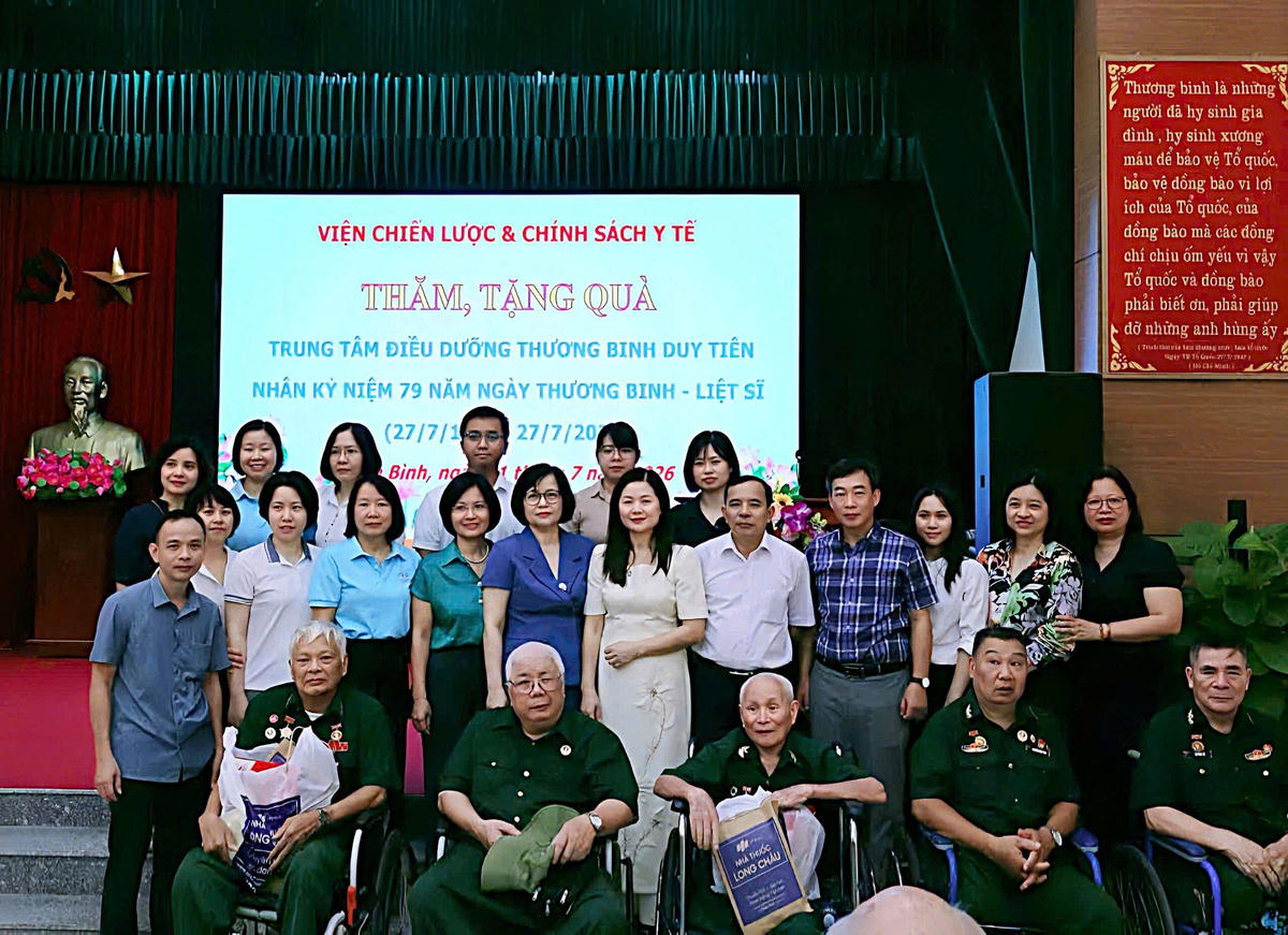 Đoàn công tác chụp ảnh lưu niệm cùng các thương binh, bệnh binh và cán bộ Trung tâm Điều dưỡng thương binh Duy Tiên. Ảnh: Viện Chiến lược và Chính sách Y tế.