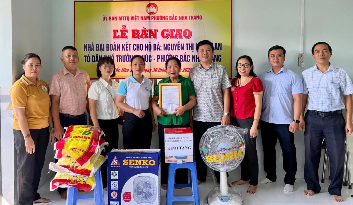 Đại diện Ủy ban MTTQ Việt Nam phường Bắc Nha Trang trao quyết định bàn giao nhà Đại đoàn kết và các phần quà hỗ trợ gia đình bà Lan.