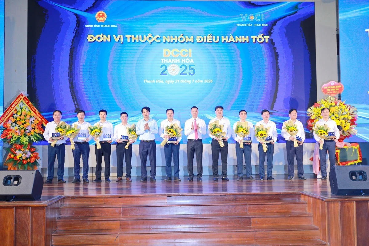 Chủ tịch UBND tỉnh Tô Anh Dũng và Trưởng ban Tuyên giáo và Dân vận Tỉnh ủy Đào Xuân Yên trao biểu trưng và tặng hoa cho các xã, phường thuộc nhóm tốt. Ảnh: Minh Hiếu